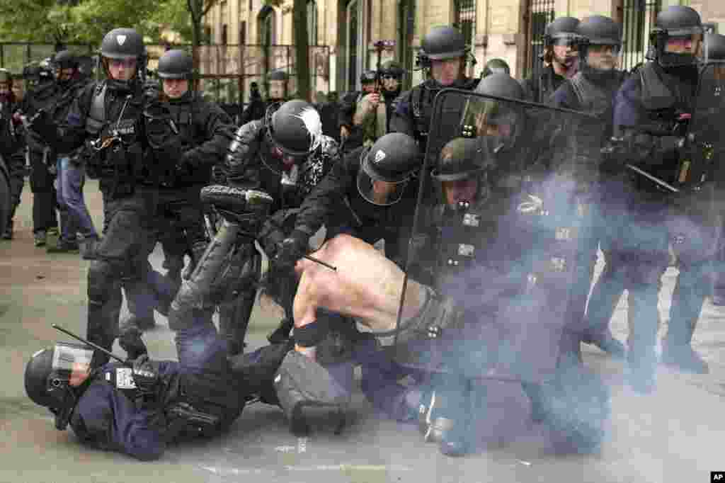 Polisi anti huru-hara Perancis menahan seorang demonstran dalam aksi menentang RUU Perburuhan di Paris.