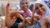 FILE - Egyptian women show their inked fingers after casting their votes at a polling station in Cairo.