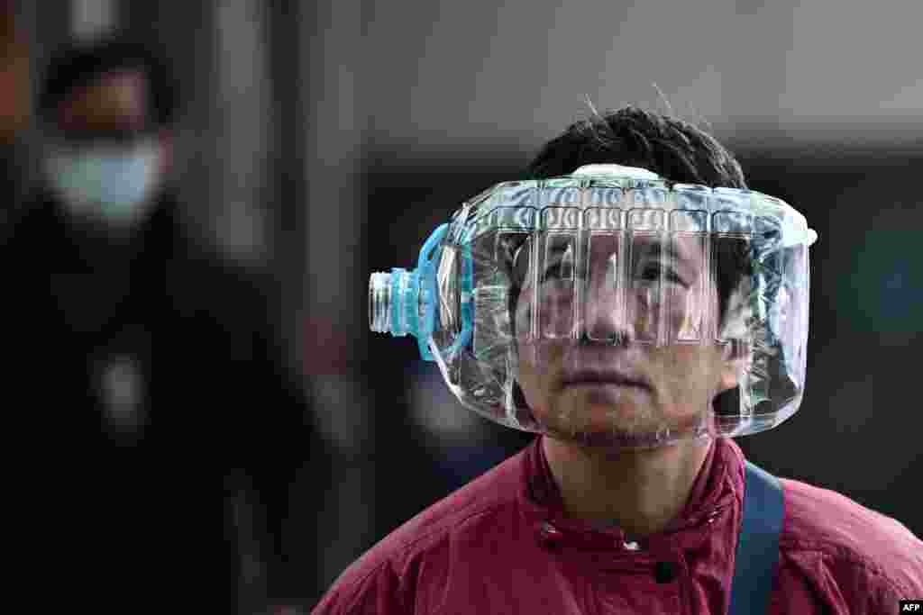 A woman wears a plastic water bottle with a cutout to cover her face, as she walks on a footbridge in Hong Kong, as a preventative measure following a virus outbreak which began in the Chinese city of Wuhan.