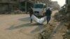  Two rescue worker from Mosul Mayoralty office remove a plastic bag containing a dead body found under the rubble of the Old City in Mosul, January 2018. (K Omar/VOA)