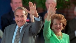 ARCHIVO - El candidato presidencial republicano Bob Dole y su esposa Elizabeth saludan a los simpatizantes en un mitin en el centro de Phoenix, el 25 de octubre de 1996.