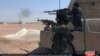 FILE - This undated image posted online July 18, 2016, by supporters of the Islamic State militant group on an anonymous photo-sharing website shows Islamic State fighters firing their weapons during clashes with the Kurdish-led Syrian Democratic Forces in Manbij, in Aleppo province, Syria. Rebels and pro-government forces were battling for control of the northern metropolis.