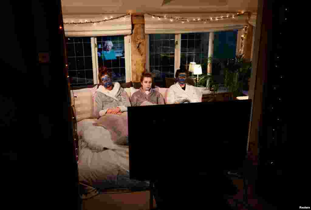 Molly, Emily and Sophie watch Britain's Queen Elizabeth II during a televised address to the nation at their home in Henton, Britain, April 5, 2020.
