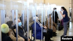 Seniors sit in a waiting room after receiving their vaccine against the coronavirus as Quebec begins vaccinations for seniors over 85 years old in Laval, Quebec, Canada, Feb. 25, 2021.