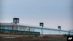 People stand in a guard tower on the perimeter wall of the Urumqi No. 3 Detention Center in Dabancheng in western China's Xinjiang Uyghur Autonomous Region on April 23, 2021. (AP Photo/Mark Schiefelbein)