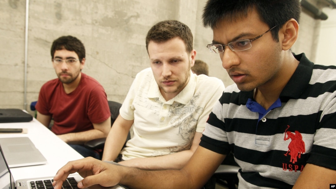 FILE - Shiva Gopalan, a computer engineering masters student at Texas A&M University (far right), confers with IBM developers Henrique Copelli Zambon (center) and Luiz Aoqui, during an IBM hosted Spark Hackathon at Galvanize, a tech hub in San Francisco, June 14, 2015.
