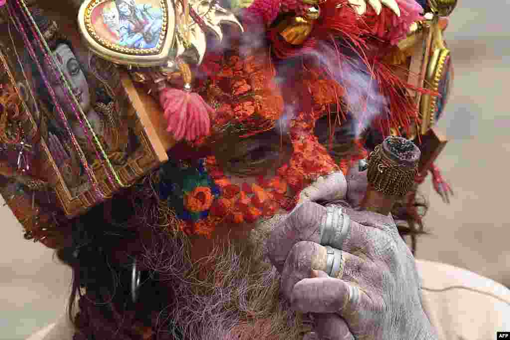 A sadhu (Hindu holy man) smokes marijuana using a "chillum," a traditional clay pipe, as a holy offering during the Hindu festival Maha Shivaratri in Kathmandu, Nepal.