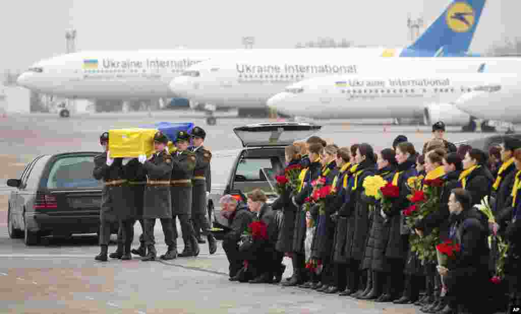 In this photo provided by the Ukrainian Presidential Press Office, honor guards carry a coffin of the one of the eleven Ukrainian victims of the Boeing 737-800 plane at Borispil international airport outside Kyiv.