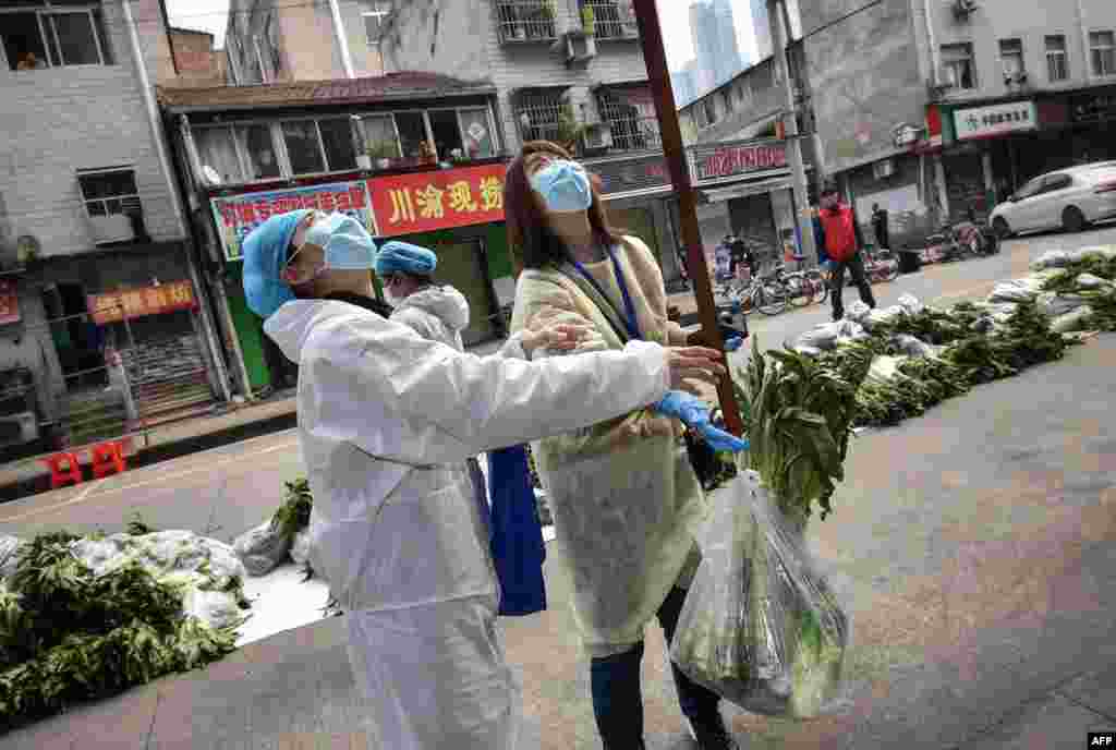 A resident, not pictured, uses a belt to have vegetables raised up in Wuhan, in China's central Hubei province, during the coronavirus pandemic.