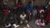 South Sudanese refugees who fled fighting between government and rebel forces wait in the shade of a dilapidated church near Aba, South Sudan to be taken to a nearby refugee camp on Dec. 19, 2017.