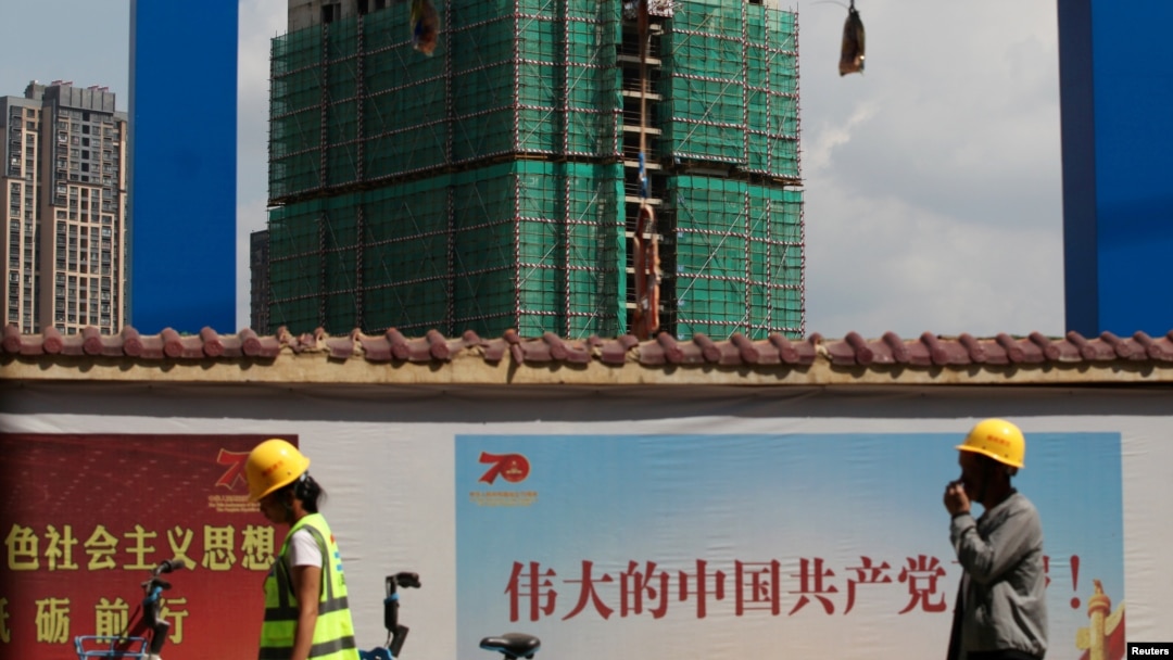 中國工人從雲南省昆明市一處建築工地旁走過。 （2019年9月17日）