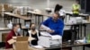 Trabajadores electorales de recuento presidencial en el Condado Fulton, en Georgia, escanean votos el 25 de noviembre de 2020, en el Georgia World Congress Center, en Atlanta.