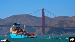FILE - A ship tows the Ocean Cleanup Project's first buoyant trash-collecting device toward the Golden Gate Bridge in San Francisco en route to the Pacific Ocean, Sept. 8, 2018. 