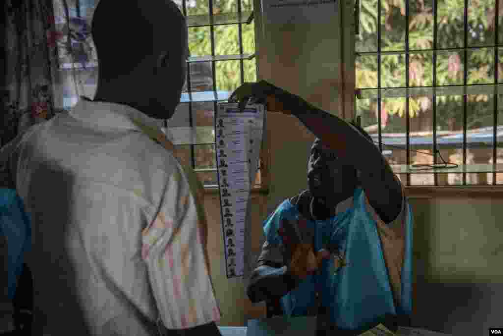 A poll worker explains a ballot for a voter in Freetown, Sierra Leone, March 7, 2018. (Photo: Jason Patinkin / VOA)