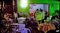 Ugandan police inspect the destroyed Ethiopian Village restaurant in Kampala after twin bomb blasts late on 11 Jul 2010 tore through crowds of football fans, 11 Jul 2010