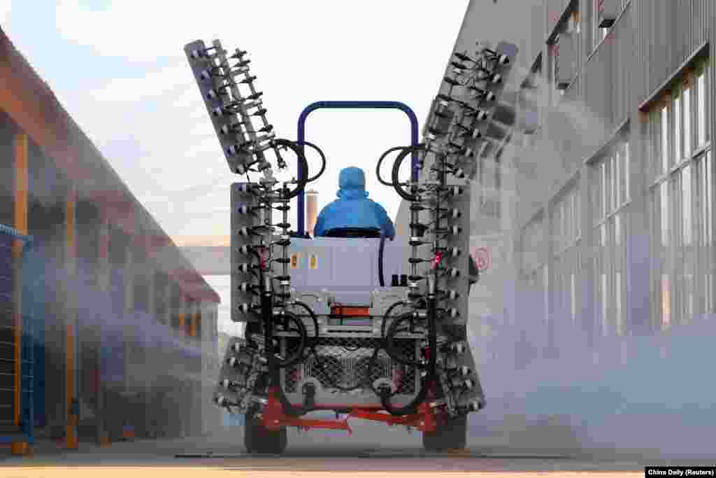 A worker operates a machine to spray disinfectants at an industrial park following an outbreak of the novel coronavirus in the country, in Yantai, Shandong province, China, Feb. 9, 2020.