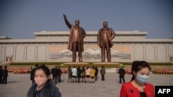 태양절인 15일 북한 평양 만수대 언덕에서 마스크를 착용한 시민들이 김일성·김정일 동상에 참배한 후 떠나고 있다. 