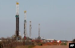 FILE - Drilling rigs dot the landscape near Calumet, Oklahoma, April 12, 2013.