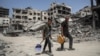 Palestinci prolaze pored srušenih zgrada u Kan Junisu na jugu Pojasa Gaze (Foto: AFP)