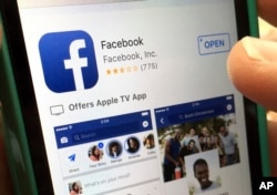 FILE - A user gets ready to launch Facebook in North Andover, Mass., June 19, 2017.