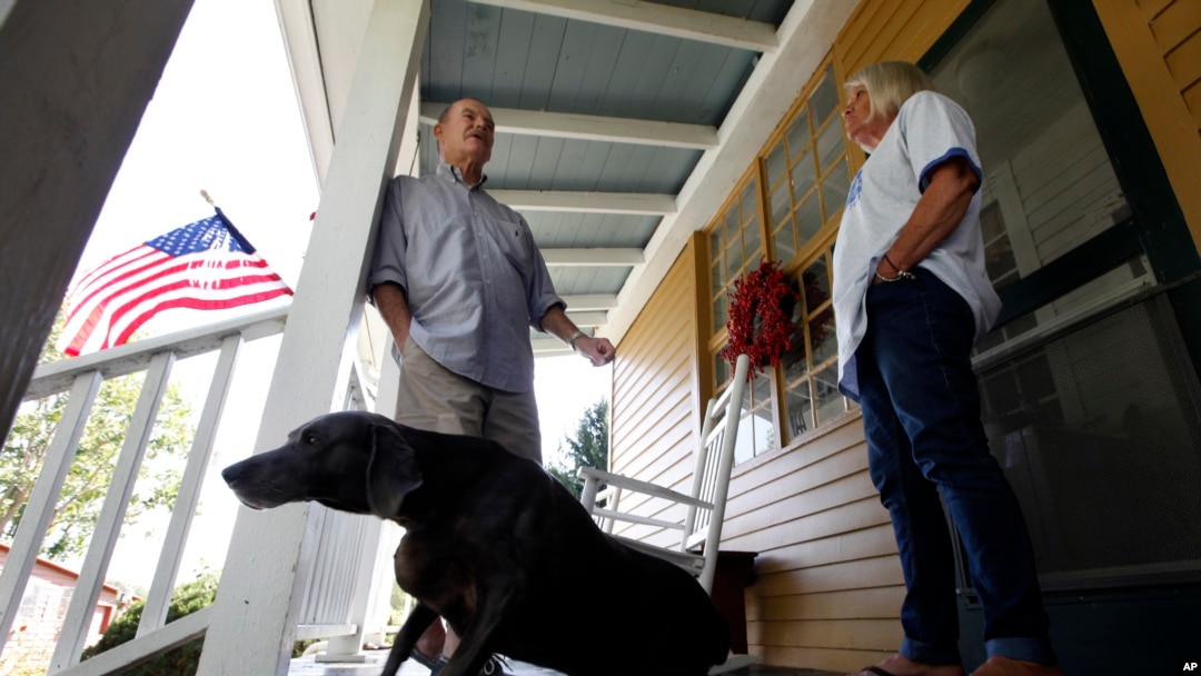 FILE - Virginia voter Harry Donahue talking to his wife Nancy on the front porch of their farmhouse, built in the 1700's, in Farmville, Va.