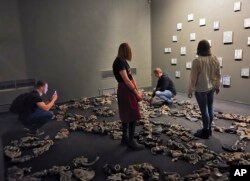 In this photo taken on Sunday, Feb. 17, 2019, visitors attend an exhibition by Russian artist Pavel Otdelnov in Moscow, Russia. (AP Photo/Ivan Kochkarev)
