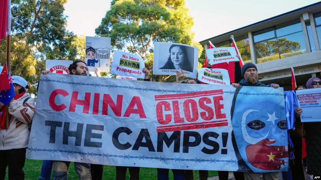 Uyghur and other demonstrators hold a banner and placards as they await the arrival of Chinese Premier Li Qiang in Adelaide, Australia, on June 16, 2024. Human rights groups said on June 20 that the U.N. must act on a two-year-old report of rights violations against the Uyghurs.
