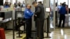 FILE An airline passenger is patted down by a TSA agent after passing through a full-body scanner at Los Angeles International Airport in Los Angeles, California, Feb. 20, 2014. The TSA is under renewed scrutiny as waiting periods for passenger screenings