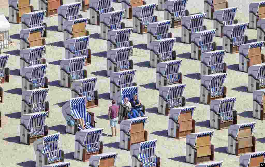People enjoy the weather in their straw baskets at the Baltic Sea beach in Warnemuende, Germany, May 30, 2020.