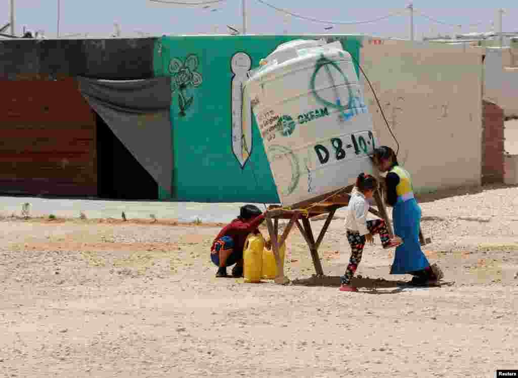 Anak-anak pengungsi Suriah mengambil air minum dari kamp Al-Zaatari di Mafraq, Yordania.