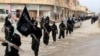 FILE - Fighters from the al-Qaida-linked Islamic State of Iraq and the Levant (ISIL), now called the Islamic State group, march in Raqqa, Syria, Jan. 14, 2014.