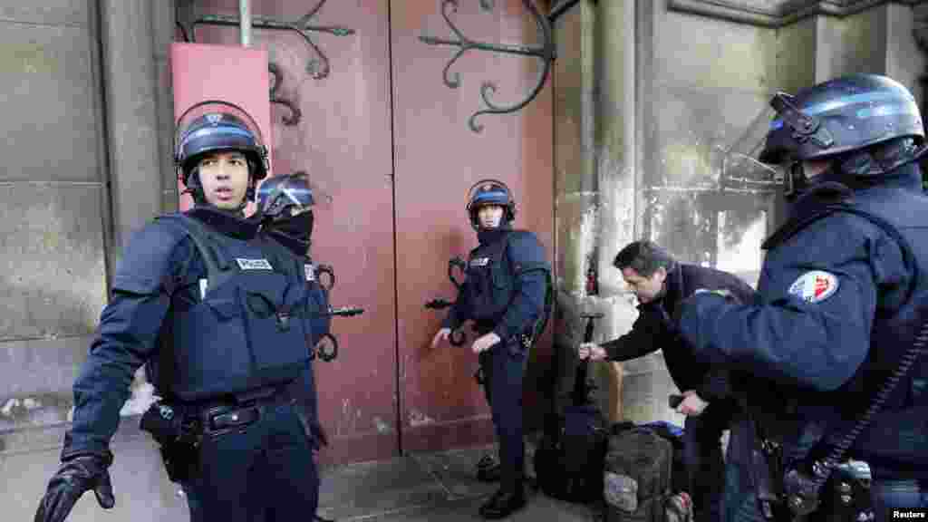 Des policiers français se déploient près de l’entrée d’une église au cours d’un raid dans la banlieue parisienne de Saint-Denis, 18 novembre 2015.