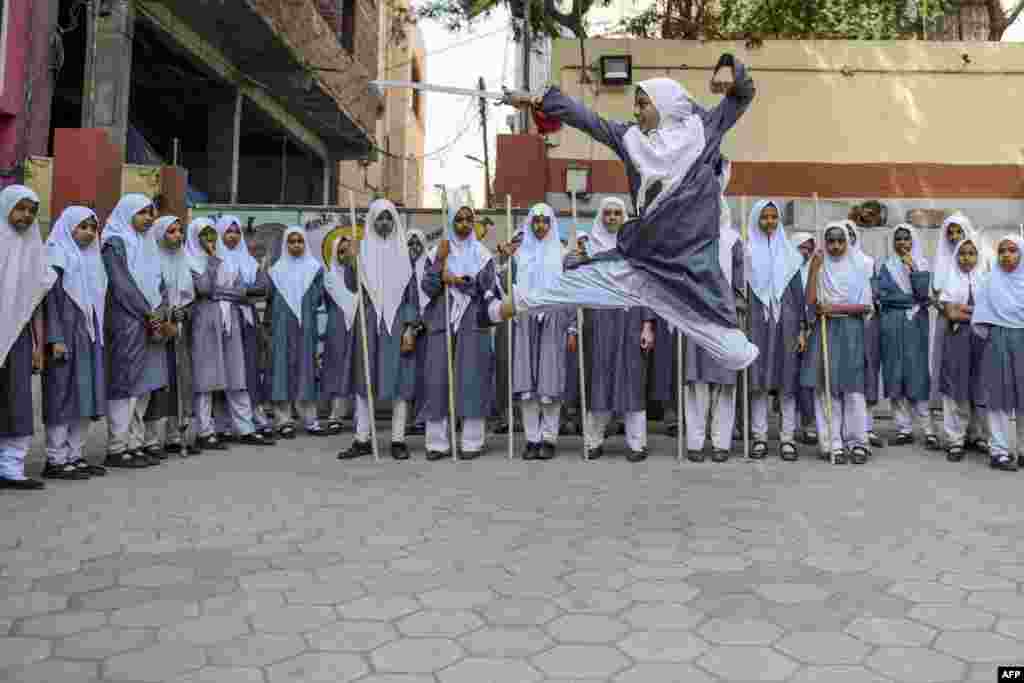 A Muslim girl practices 'Vovinam', a Vietnamese martial art of self-defense by using swords and sticks, to perform for the upcoming International Women's Day as others watch at St Maaz high school in Hyderabad, India.