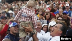 Republican presidential nominee Mitt Romney holds a baby up in the air after a campaign rally at the Golden Lamb in Lebanon, Ohio October 13, 2012.