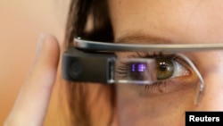 FILE - A woman wears Google glasses after a media presentation of a Google apartment in Prague, May 15, 2014. 