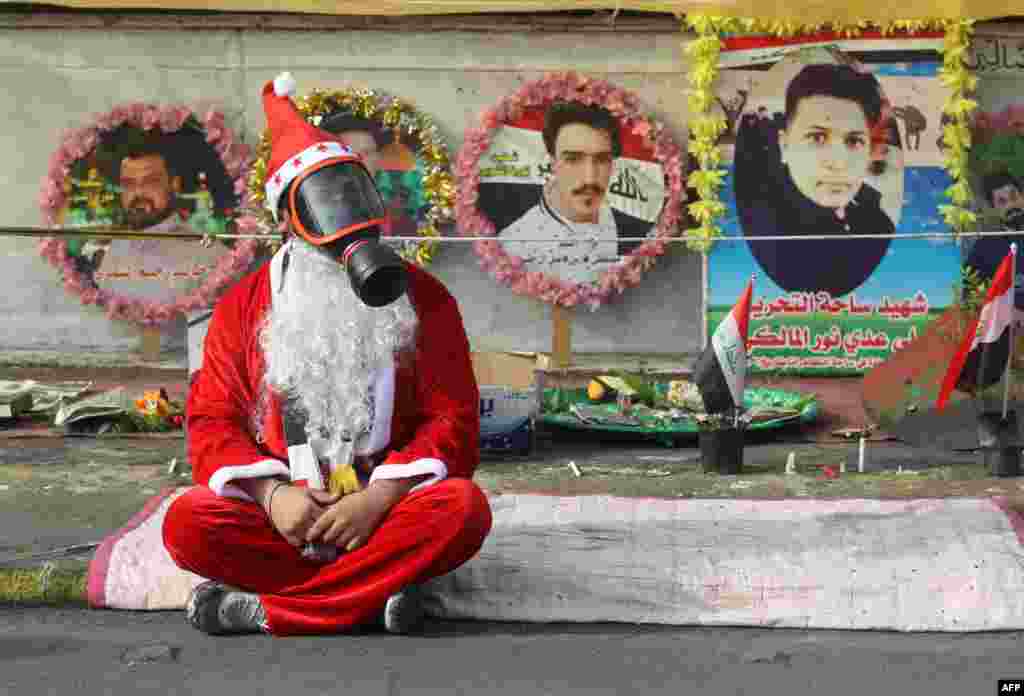 An Iraqi demonstrator wearing a Santa Claus costume and a gas mask sits on a blanket in the capital Baghdad's Tahrir Square, amid ongoing anti-government protests.