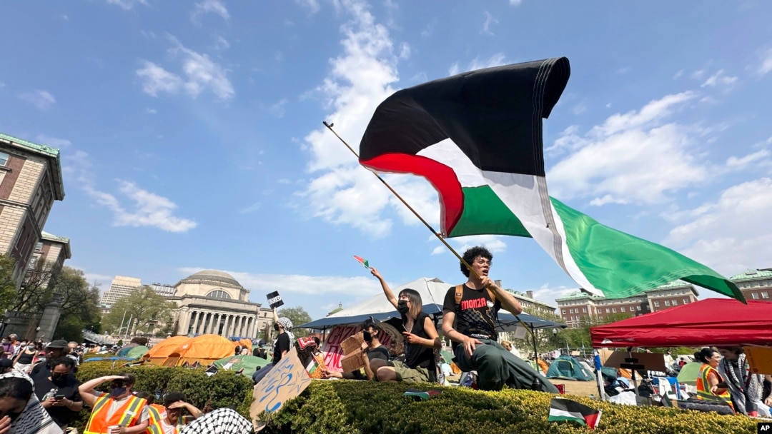 FILE - A demonstrator waves a flag on the Columbia University campus at a pro-Palestinian protest encampment, in New York, April 29, 2024.