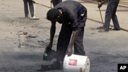 Workers outside the Qurtoba conference hall clean up debris after demonstrations by Sudanese university students and citizens yesterday in the capital Khartoum, Sudan, June 24, 2012.