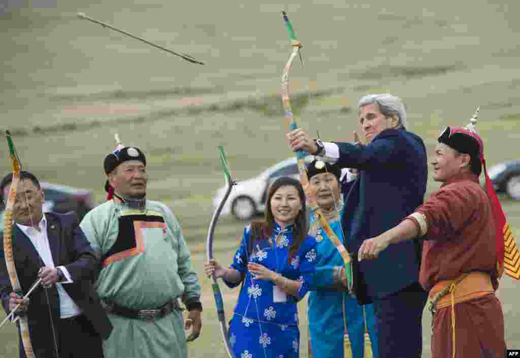 Menlu AS John Kerry ikut menembakkan panah pada kompetisi Naadam, lomba tradisional yang biasa dilakukan dengan menunggang kuda di Ulan Bator, Mongolia.