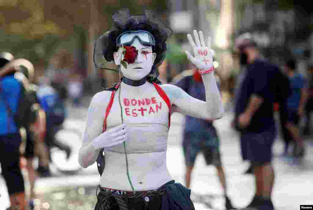 A demonstrator with words painted on her body reading "where are they?" takes part in a protest against Chile's government in Santiago, Chile, Feb. 18, 2020.