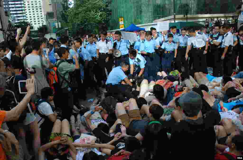 香港警方星期三凌晨展開幾波清場行動,至早上8點仍未完全將中環遮打道上預演佔中的靜坐人士全部抬走