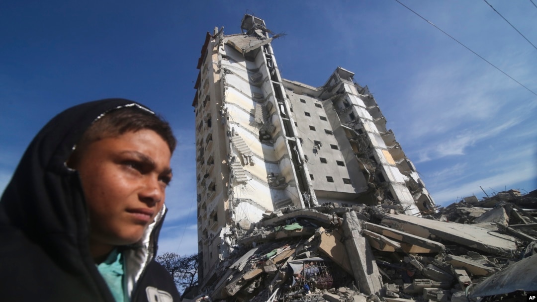 A Palestinian walks by a residential building destroyed in an Israeli strike in Rafah, Gaza Strip, on March 9, 2024.