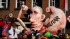 A carnival float with a caricature of Russian President Vladimir Putin moves past revelers during a carnival parade in Dusseldorf, Germany, Feb. 16, 2015. The text on the right arm reads "military;" the text on its left arm - "economy."