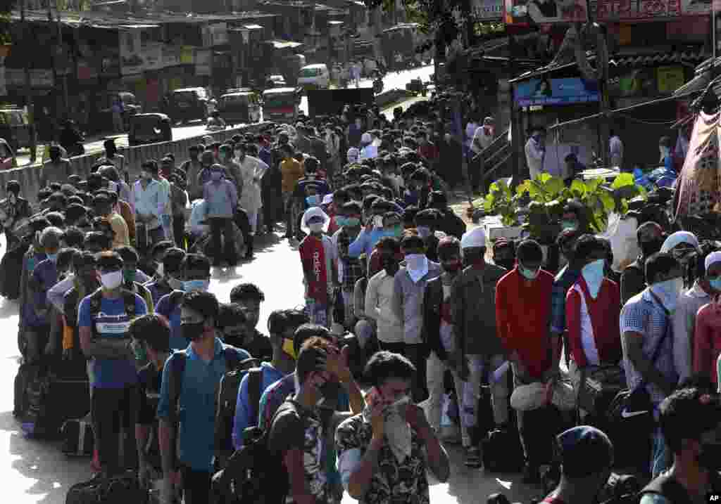 Migrant workers line up to board buses for their onward journey by train to their home states, at Dharavi, one of Asia's largest slums, in Mumbai, India.