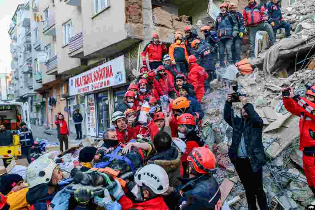 Rescue workers evacuate an injured woman from the rubble of a building after an earthquake in Elazig, eastern Turkey, Jan. 25, 2020.
