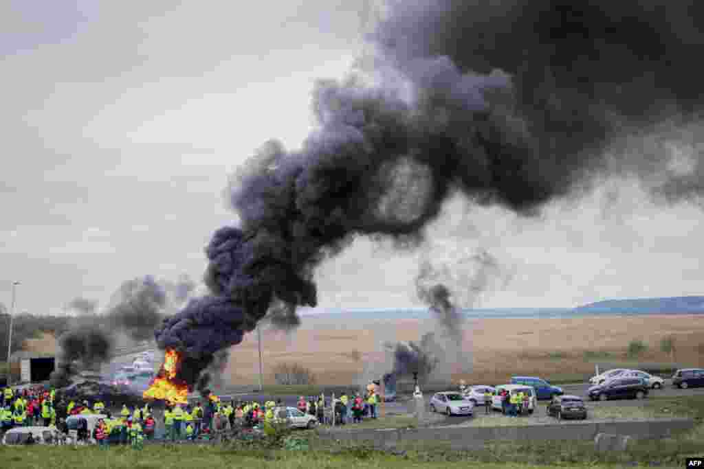 Demonstrators protesting the government's pensions overhaul burn tires as they block the entry of the industrial area of Le Havre's harbor, northwestern France.