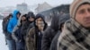Migranti čekaju u redu kako bi primili besplatan tanjir hrane, na snegu, ispred napušenog skladišta Carine u Beogradu, Srbija, 20. januara 2017. (REUTERS/Marko Djurica - RTSW2DA)