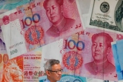 FILE - A man walks by a money exchange shop decorated with Chinese yuan in Hong Kong, Aug. 6, 2019.
