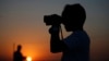 FILE - A youth looks at Turkish army tanks holding positions near the border with Syria in the outskirts of the village of Elbeyi, east of the town of Kilis, in southeastern Turkey, July 23, 2015.