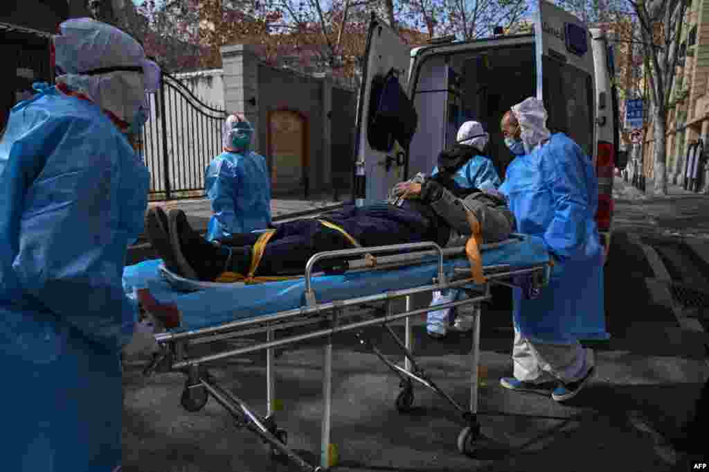 Medical staff in protective clothes are seen carrying a patient from an apartment suspected of having the virus in Wuhan, in Hubei province, China.